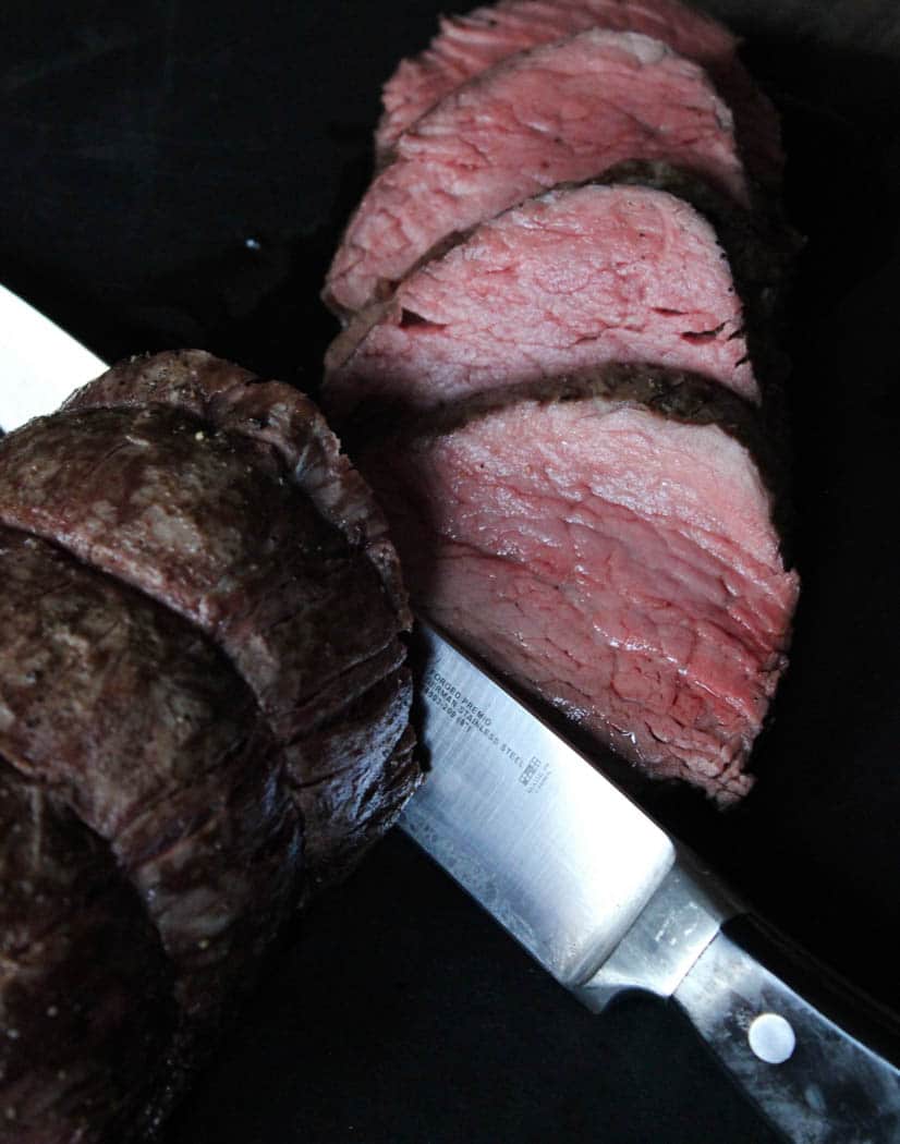 Beef tenderloin sliced after resting on a cutting board for 10 minutes.